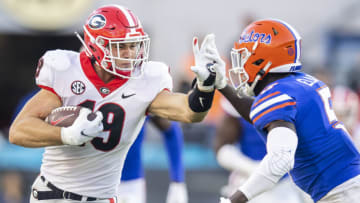 JACKSONVILLE, FLORIDA - OCTOBER 30: Brock Bowers #19 of the Georgia Bulldogs runs for yardage against Kaiir Elam #5 of the Florida Gators during the second half of a game at TIAA Bank Field on October 30, 2021 in Jacksonville, Florida. (Photo by James Gilbert/Getty Images)