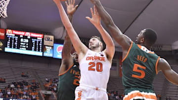 Jan 4, 2017; Syracuse, NY, USA; Syracuse Orange forward Tyler Lydon (20) takes the ball to the basket as Miami Hurricanes forward Kamari Murphy (21) and guard Davon Reed (5) defend during the second half at the Carrier Dome. Syracuse won 70-55. Mandatory Credit: Mark Konezny-USA TODAY Sports