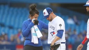 TORONTO, ON - JULY 3: Marco Estrada #25 of the Toronto Blue Jays is tended to by head athletic trainer Nikki Huffman before coming out of the game in the first inning during MLB game action against the New York Mets at Rogers Centre on July 3, 2018 in Toronto, Canada. (Photo by Tom Szczerbowski/Getty Images)