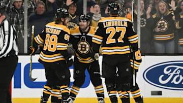 BOSTON, MASSACHUSETTS - DECEMBER 22: Jake DeBrusk #74 of the Boston Bruins celebrates with David Pastrnak #88, Hampus Lindholm #27 and Brad Marchand #63 after scoring a goal against the Winnipeg Jets during the second period at the TD Garden on December 22, 2022 in Boston, Massachusetts. (Photo by Brian Fluharty/Getty Images)