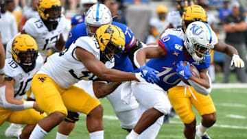 LAWRENCE, KANSAS - SEPTEMBER 21: Running back Khalil Herbert #10 of the Kansas Jayhawks tries to avoid a tackle by linebacker Josh Chandler #35 of the West Virginia Mountaineers in the first quarter at Memorial Stadium on September 21, 2019 in Lawrence, Kansas. (Photo by Ed Zurga/Getty Images)