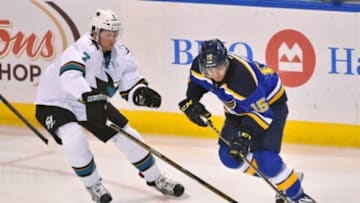 Feb 4, 2016; St. Louis, MO, USA; San Jose Sharks defenseman Paul Martin (7) reaches for the puck on St. Louis Blues center Robby Fabbri (15) during the third period at Scottrade Center. The San Jose Sharks defeat the St. Louis Blues 3-1. Mandatory Credit: Jasen Vinlove-USA TODAY Sports