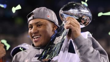 Feb 2, 2014; East Rutherford, NJ, USA; Seattle Seahawks outside linebacker Malcolm Smith (53) is awarded MVP as he hoists the Lombardi Trophy after winning Super Bowl XLVIII against the Denver Broncos at MetLife Stadium. Seattle Seahawks won 43-8. Mandatory Credit: Matthew Emmons-USA TODAY Sports