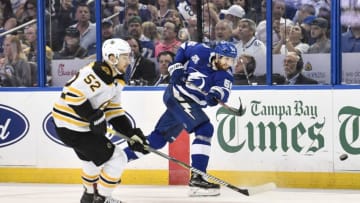 TAMPA, FL - APRIL 30: Tampa Bay Lightning defender Braydon Coburn (55) shoots the puck into the attack zone while pressured by Boston Bruins center Sean Kuraly (52) during the second period of an NHL Stanley Cup Eastern Conference Playoffs game between the Boston Bruins and the Tampa Bay Lightning on April 30, 2018, at Amalie Arena in Tampa, FL. (Photo by Roy K. Miller/Icon Sportswire via Getty Images)