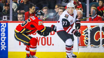 Nov 16, 2016; Calgary, Alberta, CAN; Arizona Coyotes defenseman Anthony DeAngelo (77) and Calgary Flames center Freddie Hamilton (25) battle for the puck during the first period at Scotiabank Saddledome. Mandatory Credit: Sergei Belski-USA TODAY Sports