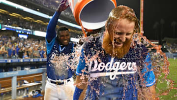 LOS ANGELES, CA - AUGUST 25: Justin Turner #10 of the Los Angeles Dodgers is soaked with sports drink by Yasiel Puig #66 after the RBI single that scored Chris Taylor #3 in the 12th inning to defeat the San Diego Padres 5-4 at Dodger Stadium on August 25, 2018 in Los Angeles, California. All players across MLB will wear nicknames on their backs as well as colorful, non-traditional uniforms featuring alternate designs inspired by youth-league uniforms during Players Weekend. (Photo by John McCoy/Getty Images)