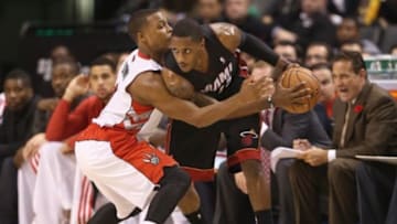 Nov 5, 2013; Toronto, Ontario, CAN; Miami Heat point guard Mario Chalmers (15) is guarded by Toronto Raptors point guard Kyle Lowry (7) at Air Canada Centre. The Heat beat the Raptors 104-95. Mandatory Credit: Tom Szczerbowski-USA TODAY Sports