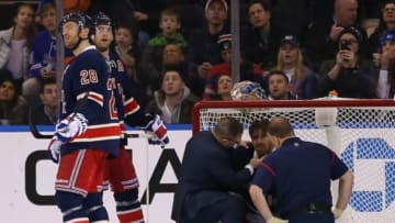 Jan 31, 2015; New York, NY, USA; New York Rangers goalie Henrik Lundqvist (30) is attended to by a team doctor and trainer after taking a puck to the throat against the Carolina Hurricanes during the second period at Madison Square Garden. Mandatory Credit: Adam Hunger-USA TODAY Sports