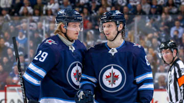WINNIPEG, MB - MARCH 28: Patrik Laine #29 and Jacob Trouba #8 of the Winnipeg Jets discuss strategy during a second period stoppage in play against the New York Islanders at the Bell MTS Place on March 28, 2019 in Winnipeg, Manitoba, Canada. (Photo by Jonathan Kozub/NHLI via Getty Images)