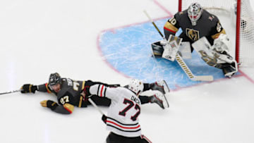 Shea Theodore #27 of the Vegas Golden Knights dives on the ice to try and block a shot on goal tender Robin Lehner #90 by Kirby Dach #77 of the Chicago Blackhawks during the third period in Game One of the Western Conference First Round. (Photo by Jeff Vinnick/Getty Images)