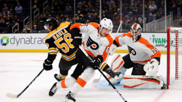 BOSTON, MASSACHUSETTS - SEPTEMBER 30: Adam Clendening #6 of the Philadelphia Flyers clears the puck away from Erik Haula #56 of the Boston Bruins during the first period of the preseason game at TD Garden on September 30, 2021 in Boston, Massachusetts. (Photo by Maddie Meyer/Getty Images)