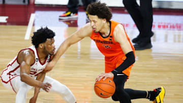 Feb 27, 2021; Norman, Oklahoma, USA; Oklahoma State Cowboys guard Cade Cunningham (2) drives to the basket against Oklahoma Sooners guard Elijah Harkless (24) during the second half at Lloyd Noble Center. Oklahoma State won 94-90. Mandatory Credit: Alonzo Adams-USA TODAY Sports
