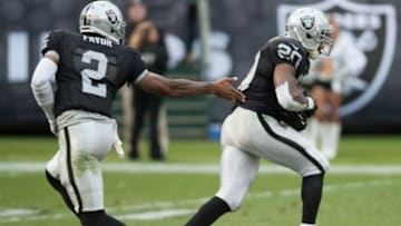 Oct 27, 2013; Oakland, CA, USA; Oakland Raiders quarterback Terrelle Pryor (2) hands the ball off to running back Darren McFadden (20) during the fourth quarter at O.co Coliseum. The Oakland Raiders defeated the Pittsburgh Steelers 21-18. Mandatory Credit: Ed Szczepanski-USA TODAY Sports