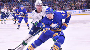 Nov 15, 2022; Buffalo, New York, USA; Buffalo Sabres defenseman Ilya Lyubushkin (46) keeps the puck from Vancouver Canucks in the third period at KeyBank Center. Mandatory Credit: Mark Konezny-USA TODAY Sports