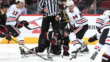 GLENDALE, ARIZONA - FEBRUARY 01: Brad Richardson #15 of the Arizona Coyotes reaches for the puck after a face-off with David Kampf #64 of the Chicago Blackhawks during the second period of the NHL hockey game at Gila River Arena on February 01, 2020 in Glendale, Arizona. (Photo by Norm Hall/NHLI via Getty Images)