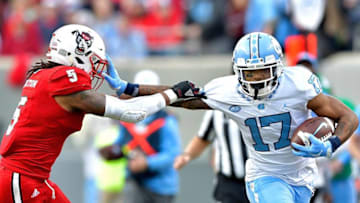 RALEIGH, NC - NOVEMBER 25: Anthony Ratliff-Williams #17 of the North Carolina Tar Heels stiff-arms Johnathan Alston #5 of the North Carolina State Wolfpack during their game at Carter Finley Stadium on November 25, 2017 in Raleigh, North Carolina. (Photo by Grant Halverson/Getty Images)
