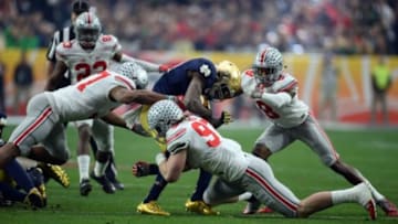 Jan 1, 2016; Glendale, AZ, USA; Notre Dame Fighting Irish running back Josh Adams (33) is tackled by Ohio State Buckeyes linebacker Joshua Perry (37) and Ohio State Buckeyes defensive lineman Joey Bosa (97) an Ohio State Buckeyes cornerback Gareon Conley (8) during the first half of the 2016 Fiesta Bowl at University of Phoenix Stadium. Mandatory Credit: Joe Camporeale-USA TODAY Sports