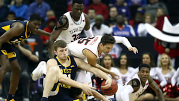 KANSAS CITY, MISSOURI - MARCH 14: Davide Moretti #25 of the Texas Tech Red Raiders and Logan Routt #31 of the West Virginia Mountaineers battle for a loose ball during the quarterfinal game of the Big 12 Basketball Tournament at Sprint Center on March 14, 2019 in Kansas City, Missouri. (Photo by Jamie Squire/Getty Images)