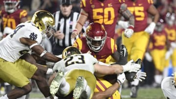 LOS ANGELES, CA - NOVEMBER 24: Amon-Ra St. Brown #8 of the USC Trojans attempts to recover the ball between his legs after fumbling it but Drue Tranquill #23 of the Notre Dame Fighting Irish recovers it during the first half at Los Angeles Memorial Coliseum on November 24, 2018 in Los Angeles, California. (Photo by Kevork Djansezian/Getty Images)