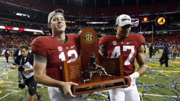 Dec 5, 2015; Atlanta, GA, USA; Alabama Crimson Tide quarterback David Cornwell (12) and Christian Miller (47) carry the trophy after the 2015 SEC Championship Game at the Georgia Dome. Alabama won 29-15. Mandatory Credit: Jason Getz-USA TODAY Sports