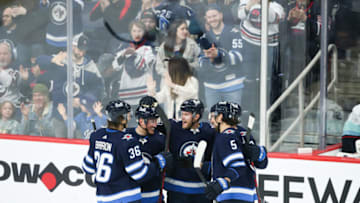 May 1, 2022; Winnipeg, Manitoba, CAN; Winnipeg Jets forward Dominic Toninato (21) is congratulated by his team mates on his goal against Seattle Kraken goalie Chris Driedger (60) during the third period at Canada Life Centre. Mandatory Credit: Terrence Lee-USA TODAY Sports