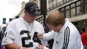 Sep 27, 2014; London, UNITED KINGDOM; Oakland Raiders owner Mark Davis autographs the jersey of Nathan Stieg (24) at NFL on Regent Street in advance of the International Series game between the Miami Dolphins and the Raiders. Mandatory Credit: Kirby Lee-USA TODAY Sports