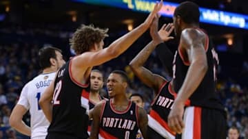 November 23, 2013; Oakland, CA, USA; Portland Trail Blazers point guard Damian Lillard (0) celebrates with his team during the fourth quarter against the Golden State Warriors at Oracle Arena. The Trail Blazers defeated the Warriors 113-101. Mandatory Credit: Kyle Terada-USA TODAY Sports