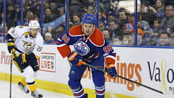 Mar 14, 2016; Edmonton, Alberta, CAN; Edmonton Oilers defensemen Nikita Nikitin (86) plays the puck while being chased by Nashville Predators forward Miikka Salomaki (20) during the third period at Rexall Place. Mandatory Credit: Perry Nelson-USA TODAY Sports