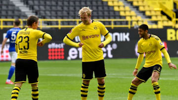 Dortmund's Belgian forward Thorgan Hazard celebrates with Dortmund's German forward Julian Brandt (C) after scoring his side's third goal during the German first division Bundesliga football match BVB Borussia Dortmund v Schalke 04 on May 16, 2020 in Dortmund, western Germany as the season resumed following a two-month absence due to the novel coronavirus COVID-19 pandemic. (Photo by Martin Meissner / POOL / AFP) / DFL REGULATIONS PROHIBIT ANY USE OF PHOTOGRAPHS AS IMAGE SEQUENCES AND/OR QUASI-VIDEO (Photo by MARTIN MEISSNER/POOL/AFP via Getty Images)