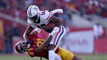 LOS ANGELES, CALIFORNIA - OCTOBER 30: Jamarye Joiner #10 of the Arizona Wildcats is tackled by Hunter Echols #31 of the USC Trojans after his catch during the first half at Los Angeles Memorial Coliseum on October 30, 2021 in Los Angeles, California. (Photo by Harry How/Getty Images)