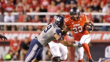 Sep 11, 2015; Salt Lake City, UT, USA; Utah Utes running back Devontae Booker (23) carries the ball as Utah State Aggies linebacker Kyler Fackrell (9) attempts to make the tackle during the first half at Rice-Eccles Stadium. Utah won 24-14. Mandatory Credit: Russ Isabella-USA TODAY Sports