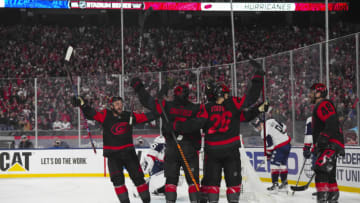 Feb 18, 2023; Raleigh, North Carolina, USA; Carolina Hurricanes center Paul Stastny (26) celebrates with left wing Jordan Martinook (48) and defenseman Jalen Chatfield (5) and defenseman Calvin de Haan (44) after scoring a goal against the Washington Capitals during the second period during the 2023 Stadium Series ice hockey game at Carter-Finley Stadium. Mandatory Credit: James Guillory-USA T ODAY Sports