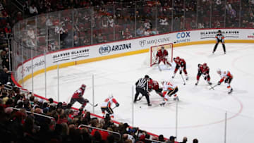GLENDALE, ARIZONA - DECEMBER 10: Brad Richardson #15 of the Arizona Coyotes faces off against Mark Jankowski #77 of the Calgary Flames during the first period of the NHL game at Gila River Arena on December 10, 2019 in Glendale, Arizona. The Flames defeated the Coyotes 5-2. (Photo by Christian Petersen/Getty Images)