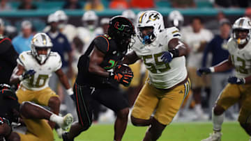 Oct 7, 2023; Miami Gardens, Florida, USA; Miami Hurricanes running back Henry Parrish Jr. (21) runs the ball around Georgia Tech Yellow Jackets offensive lineman Will Scissum (59) in the second half at Hard Rock Stadium. Mandatory Credit: Jasen Vinlove-USA TODAY Sports