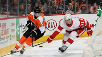 PHILADELPHIA, PA - DECEMBER 18: Shayne Gostisbehere #53 of the Philadelphia Flyers battles for the loose puck behind the net with Dylan Larkin #71 of the Detroit Red Wings on December 18, 2018 at the Wells Fargo Center in Philadelphia, Pennsylvania. (Photo by Len Redkoles/NHLI via Getty Images)