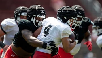 Cincinnati Bearcats defensive lineman Eric Phillips tackles running back Ethan Wright during the spring scrimmage at Nippert Stadium. The Enquirer.