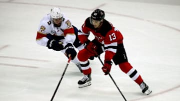 NEWARK, NJ - OCTOBER 27: Nico Hischier #13 of the New Jersey Devils skates with the puck against Aaron Ekblad #5 of the Florida Panthers at the Prudential Center on October 27, 2018 in Newark, New Jersey. (Photo by Eliot J. Schechter/NHLI via Getty Images)