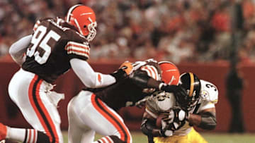 Pittsburgh Steelers running back Jerome Bettis (R) carries the ball for a first down before being tackled by Cleveland Browns players Wali Rainer (C) and Jamir Miller (L) during the first quarter 12 September, 1999, at Cleveland Browns Stadium in Cleveland, OH. The Browns lost to the Steelers 43-0. AFP PHOTO David MAXWELL (Photo by DAVID MAXWELL / AFP) (Photo by DAVID MAXWELL/AFP via Getty Images)