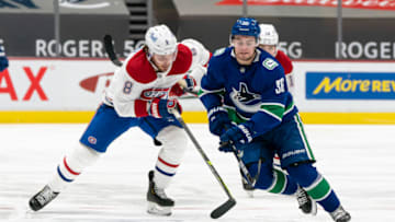 VANCOUVER, BC - MARCH 08: Nils Hoglander #36 of the Vancouver Canucks beats Ben Chiarot #8 of the Montreal Canadiens to the loose puck during NHL hockey action at Rogers Arena on March 8, 2021 in Vancouver, Canada. (Photo by Rich Lam/Getty Images)