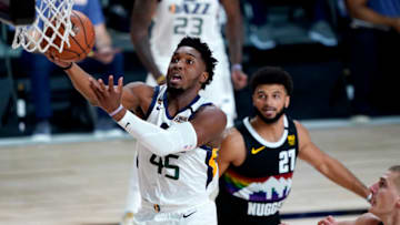 LAKE BUENA VISTA, FLORIDA - AUGUST 19: Donovan Mitchell #45 of the Utah Jazz drives to the basket as Jamal Murray #27 of the Denver Nuggets look on during the first half of Game Two of a first round playoff game at AdventHealth Arena at ESPN Wide World Of Sports Complex on August 19, 2020 in Lake Buena Vista, Florida. NOTE TO USER: User expressly acknowledges and agrees that, by downloading and or using this photograph, User is consenting to the terms and conditions of the Getty Images License Agreement. (Photo by Ashley Landis-Pool/Getty Images)