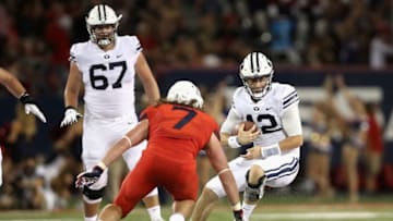 TUCSON, AZ - SEPTEMBER 01: Quarterback Tanner Mangum #12 of the Brigham Young Cougars scrambles against linebacker Colin Schooler #7 of the Arizona Wildcats during the college football game at Arizona Stadium on September 1, 2018 in Tucson, Arizona. The Cougars defeated the Wildcats 28-23. (Photo by Christian Petersen/Getty Images)