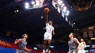 Dec 3, 2020; Lawrence, Kansas, USA; Kansas Jayhawks guard Tyon Grant-Foster (1) shoots a layup against Washburn Ichabods guard Drew Maschoff (5) and guard Levi Braun (13) during the first half at Allen Fieldhouse. Mandatory Credit: Jay Biggerstaff-USA TODAY Sports