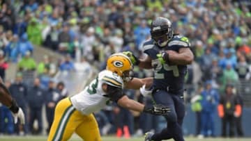 Jan 18, 2015; Seattle, WA, USA; Seattle Seahawks running back Marshawn Lynch (24) carries the ball as Green Bay Packers outside linebacker Nick Perry (53) attempts the tackle during the third quarter in the NFC Championship Game at CenturyLink Field. Mandatory Credit: Kirby Lee-USA TODAY Sports