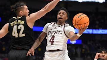 Mar 11, 2023; Nashville, TN, USA; Texas A&M Aggies guard Wade Taylor IV (4) goes under the arms of Vanderbilt Commodores forward Quentin Millora-Brown (42) during the second half at Bridgestone Arena. Mandatory Credit: Steve Roberts-USA TODAY Sports