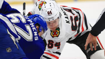 TAMPA, FLORIDA - JANUARY 13: David Kampf #64 of the Chicago Blackhawks faces off against Mitchell Stephens #67 of the Tampa Bay Lightning during a game on opening night of the 2020-21 NHL season at Amalie Arena on January 13, 2021 in Tampa, Florida. (Photo by Mike Ehrmann/Getty Images)