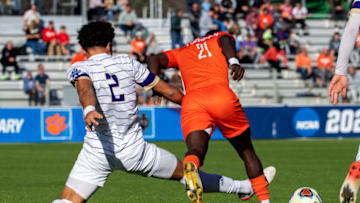 Dec 12, 2021; Cary, NC, USA; Clemson midfielder Ousmane Sylla (21) with the ball as Washington defender Kendall Burks (2) defends in the first half at WakeMed Soccer Park. Mandatory Credit: Bob Donnan-USA TODAY Sports