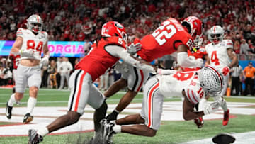 Dec 31, 2022; Atlanta, Georgia, USA; Ohio State Buckeyes wide receiver Marvin Harrison Jr. (18) takes a hit from Georgia Bulldogs defensive back Javon Bullard (22) during the second half of the Peach Bowl in the College Football Playoff semifinal at Mercedes-Benz Stadium. Ohio State lost 42-41. Mandatory Credit: Adam Cairns-The Columbus DispatchNcaa Football Peach Bowl Ohio State At Georgia