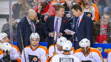 Nov 5, 2015; Calgary, Alberta, CAN; Philadelphia Flyers head coach Dave Hakstol (middle) on his bench against the Calgary Flames during the overtime period at Scotiabank Saddledome. Calgary Flames won 2-1. Mandatory Credit: Sergei Belski-USA TODAY Sports