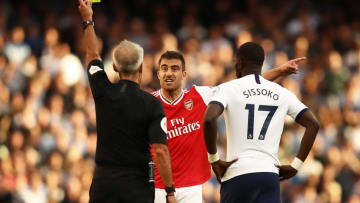 LONDON, ENGLAND - SEPTEMBER 01: Sokratis of Arsenal is shown a yellow card by referee Martin Atkinson during the Premier League match between Arsenal FC and Tottenham Hotspur at Emirates Stadium on September 01, 2019 in London, United Kingdom. (Photo by Julian Finney/Getty Images)
