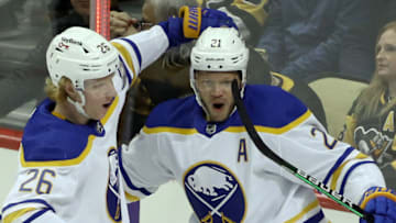 Nov 16, 2021; Pittsburgh, Pennsylvania, USA; Buffalo Sabres defenseman Rasmus Dahlin (26) and right wing Kyle Okposo (21) celebrate a goal by Okposo against the Pittsburgh Penguins during the second period at PPG Paints Arena. Mandatory Credit: Charles LeClaire-USA TODAY Sports